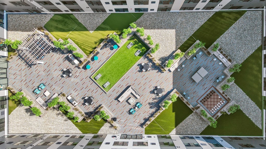 A top-down view of a courtyard surrounded by buildings with a patterned border.
