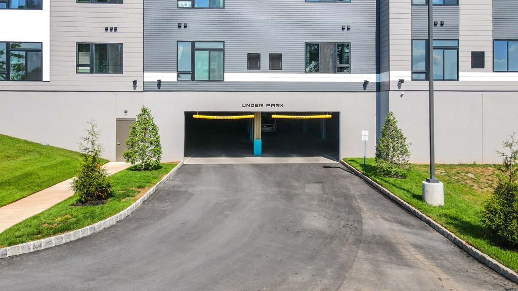 A road leading to a tunnel entrance under a building with the words "Under Park" written on it.
