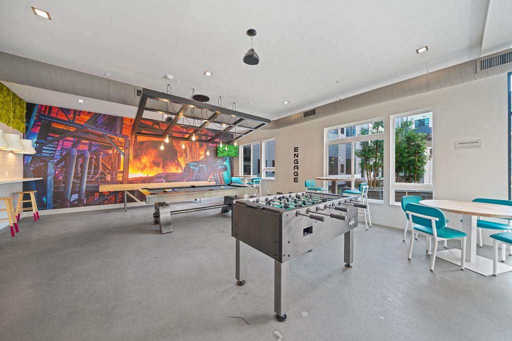 A room with a table and chairs and a mural on the wall.