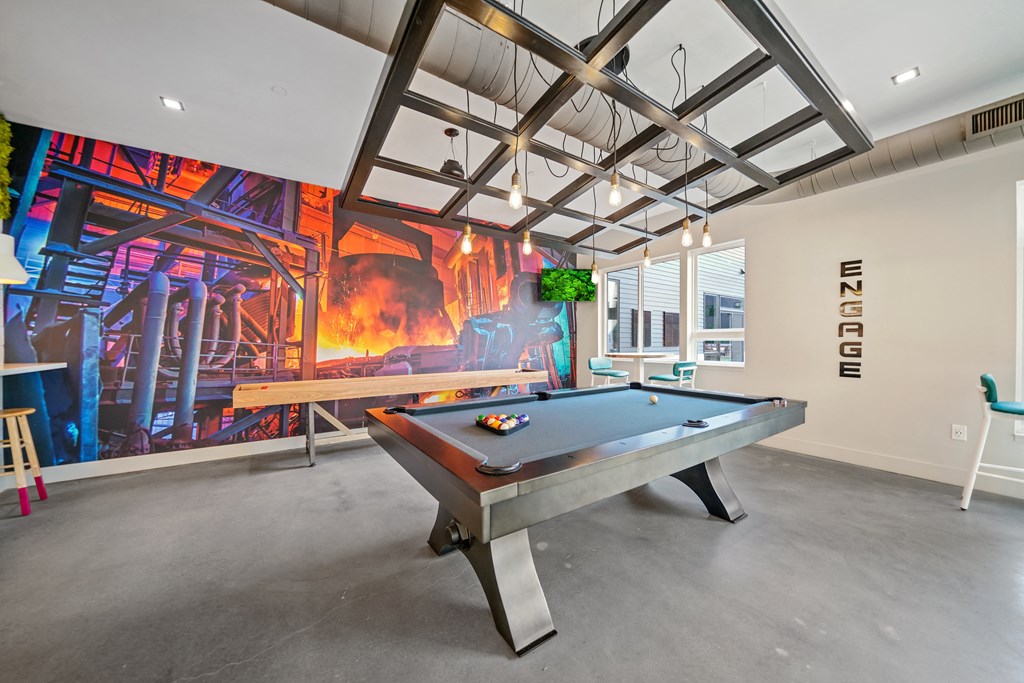 A pool table in a room with a large mural on the wall.