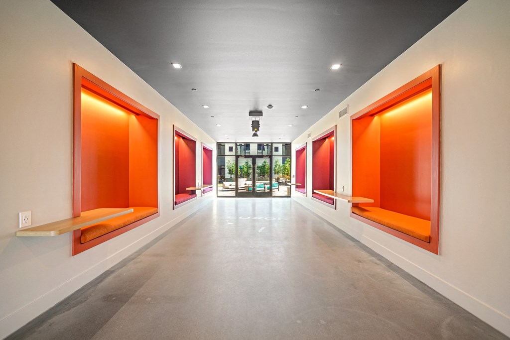 A long hallway with orange frames on the wall.