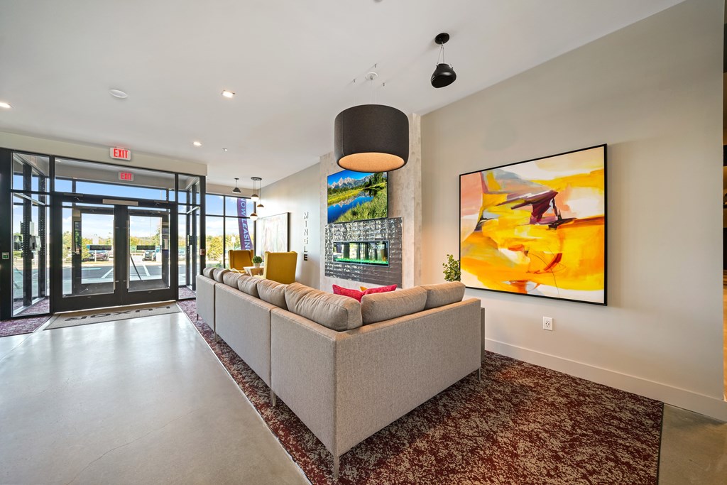 A large painting hangs on the wall in a spacious room.