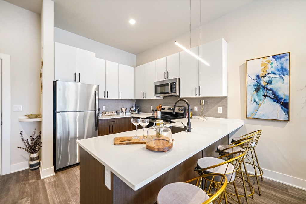A modern kitchen with a white island and stainless steel appliances.