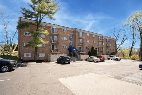 A parking lot in front of a brick apartment building.