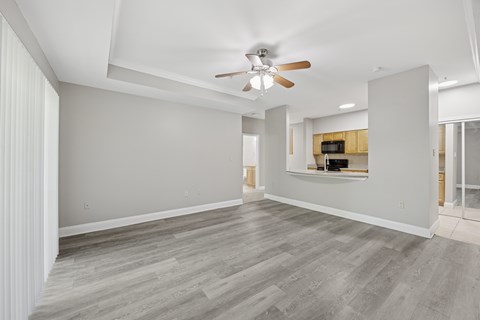 A spacious room with a ceiling fan and a wooden cabinet.