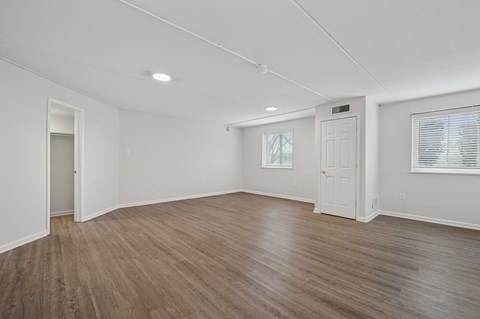 A room with wooden flooring and white walls.