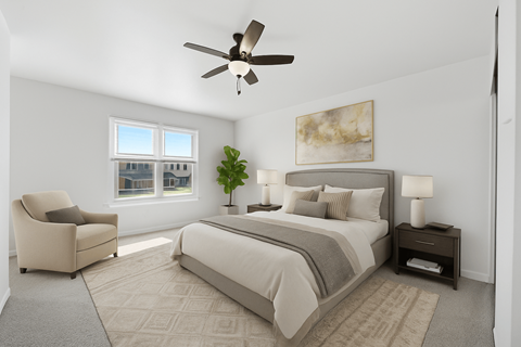 A bedroom with a large bed, a chair, and a ceiling fan.