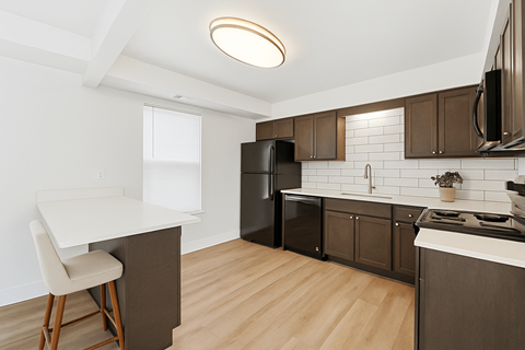 A kitchen with brown cabinets and a white counter.