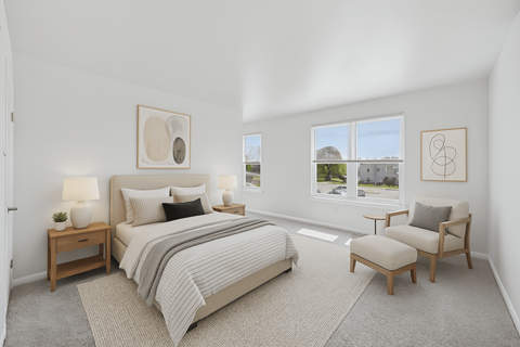 A bedroom with a large bed, a chair, and a table with lamps.