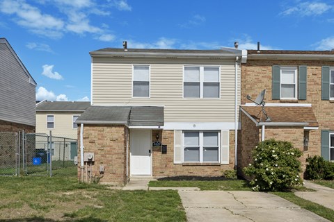 A two-story house with a white door and a grey roof.