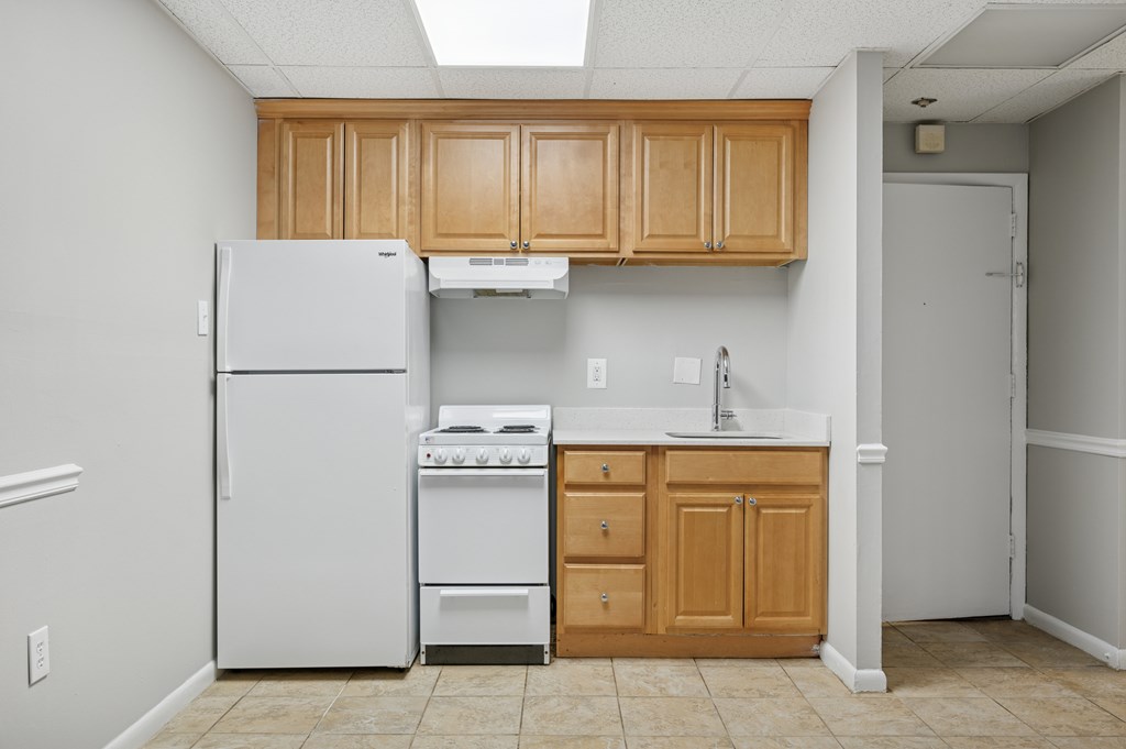 A kitchen with white appliances and wooden cabinets.