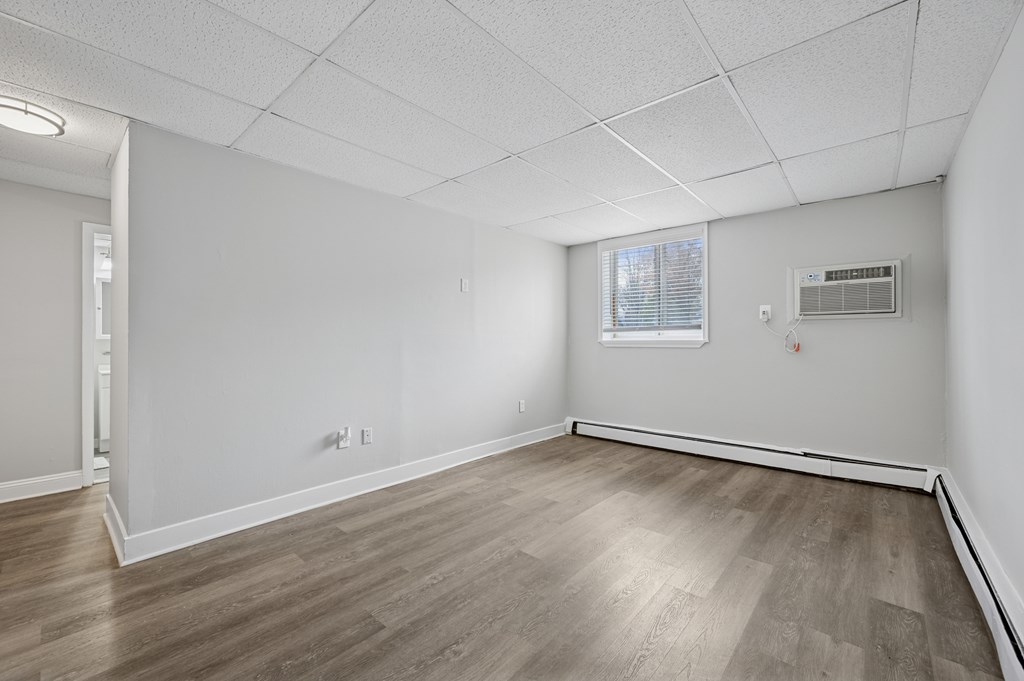 A room with wooden flooring and white walls.