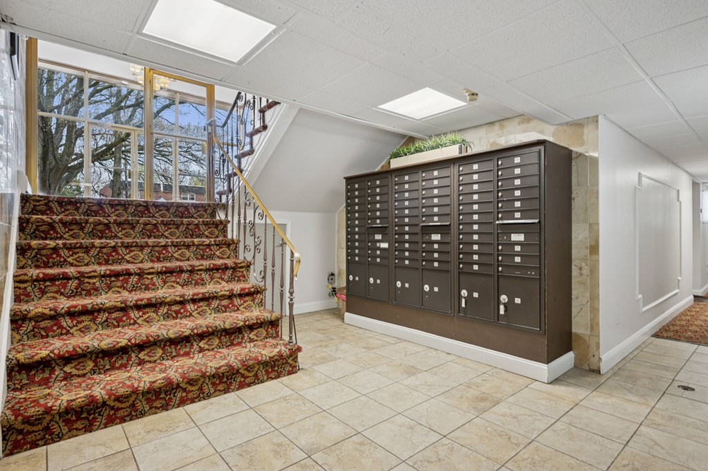 A staircase with a red carpet and a wall of lockers.