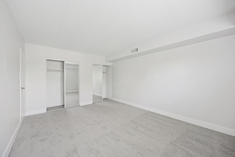 A large empty room with carpeted floor and white walls.
