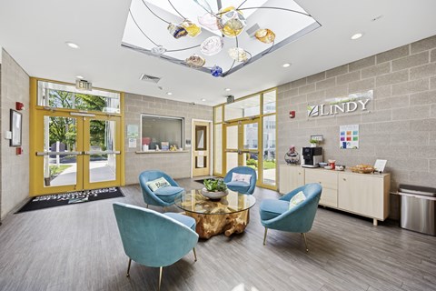 A reception area with blue chairs and a sign that says "Zindy".