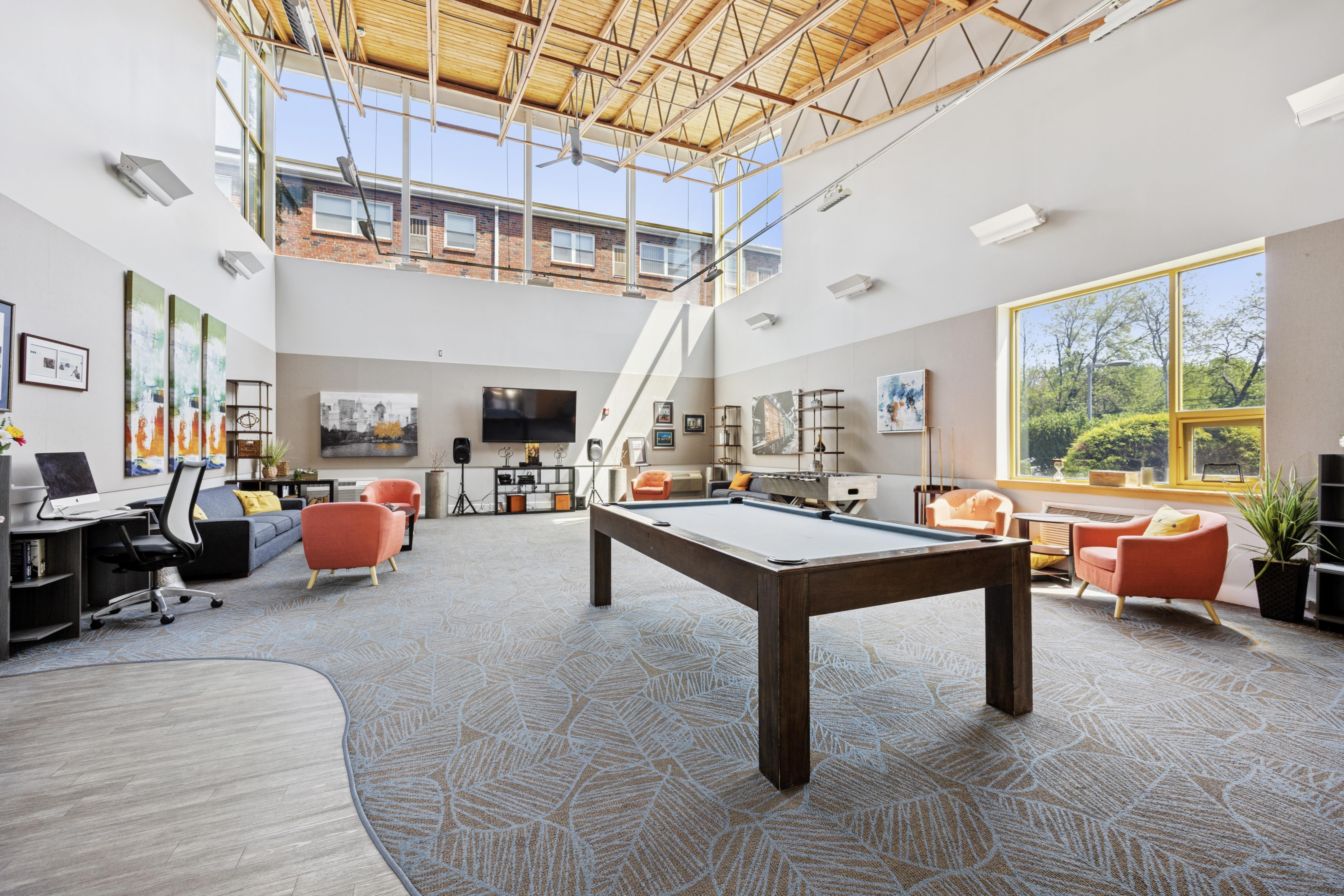 A spacious room with a pool table and comfortable seating.