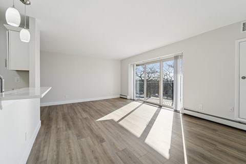 A room with a white wall and a sliding glass door.