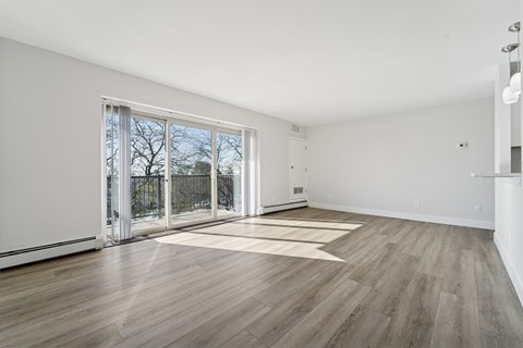 A room with a sliding glass door leading to a balcony.