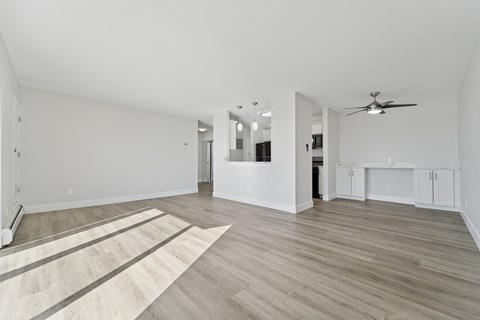 A spacious room with sunlight pouring in through the balcony door.
