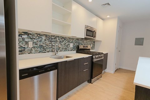 A kitchen with a stove top oven and a microwave above it.