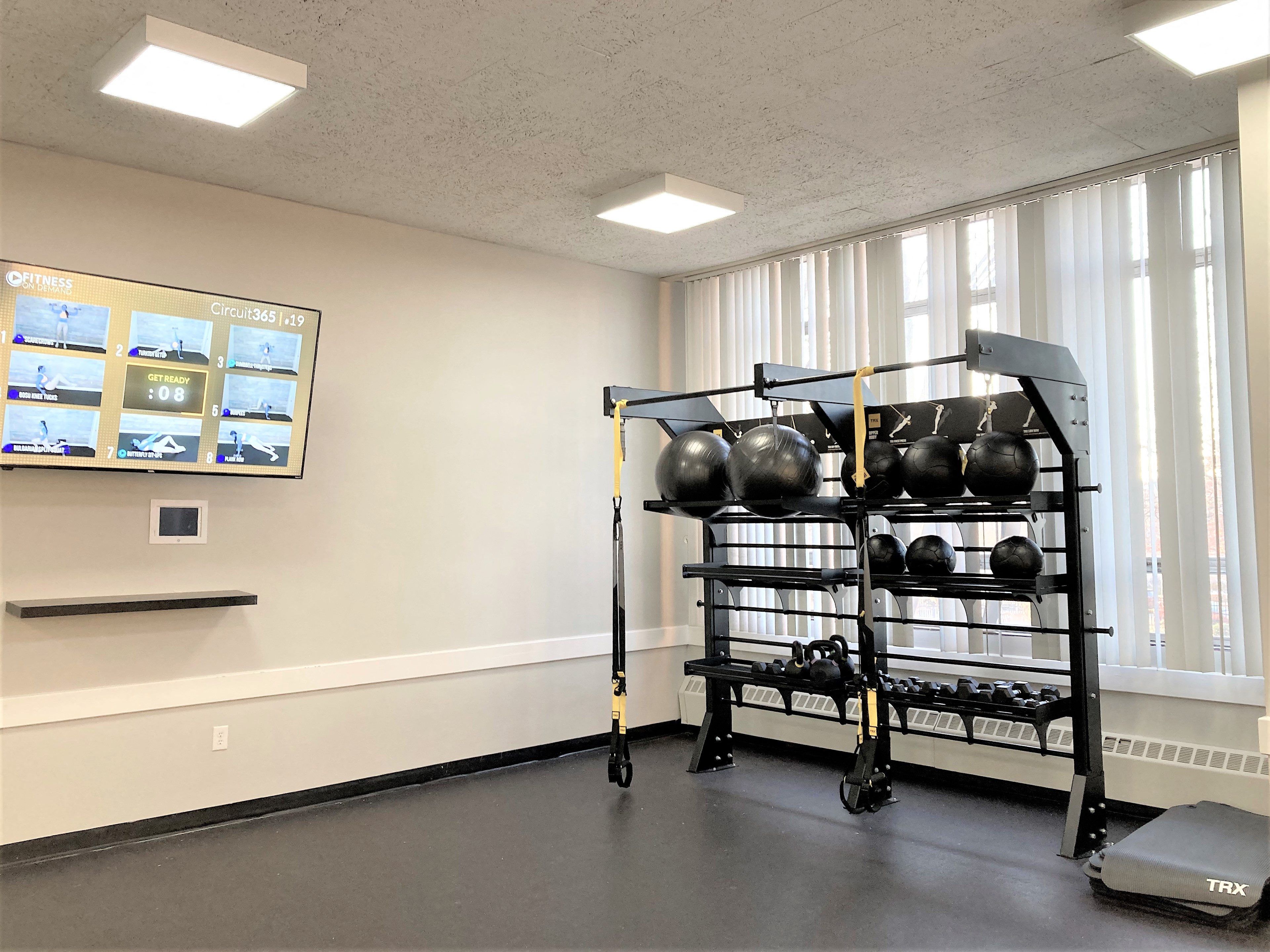 a gym with weights and a cart in the corner of a room
