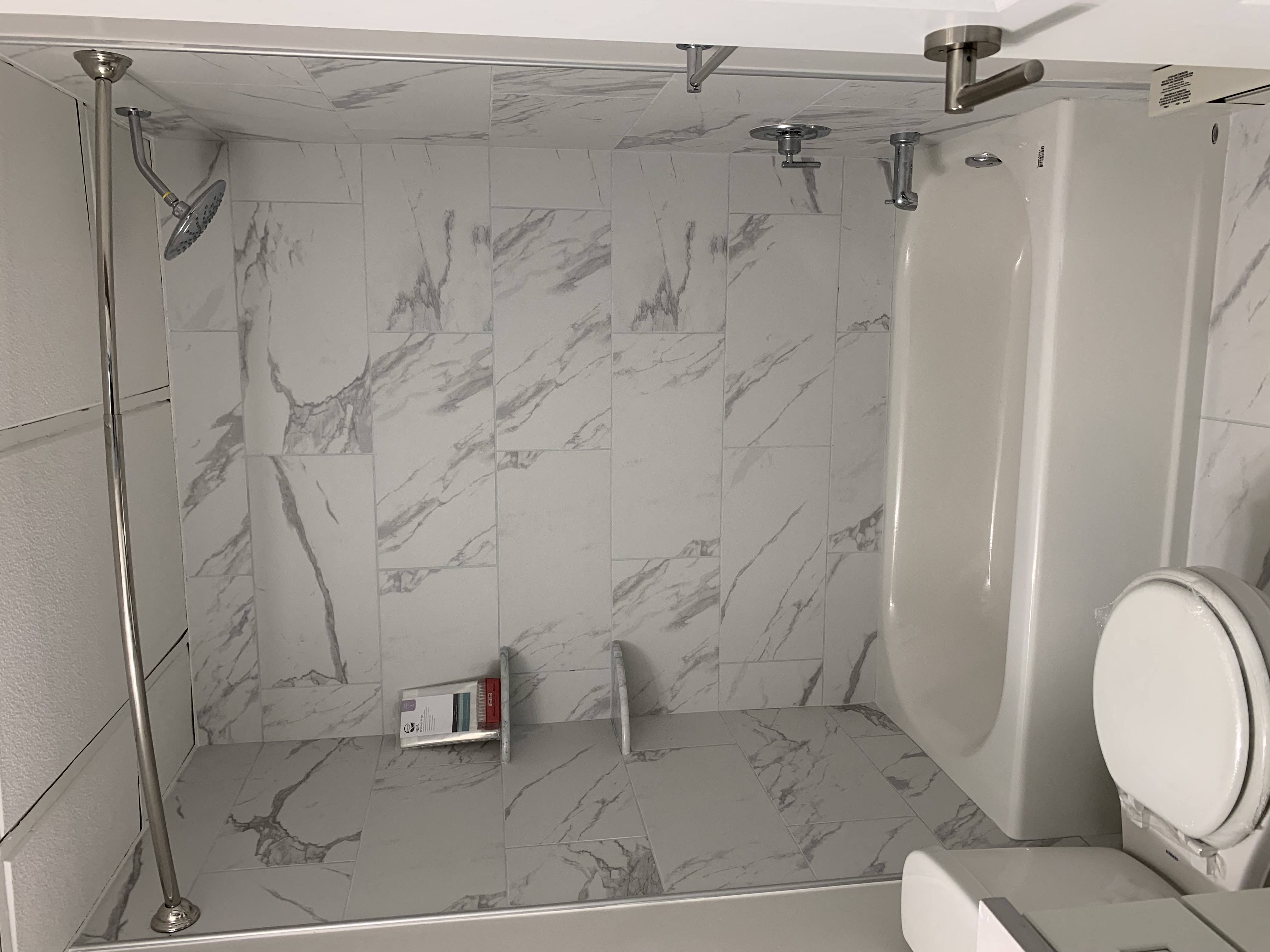 a bathroom with a toilet and a marbled shower