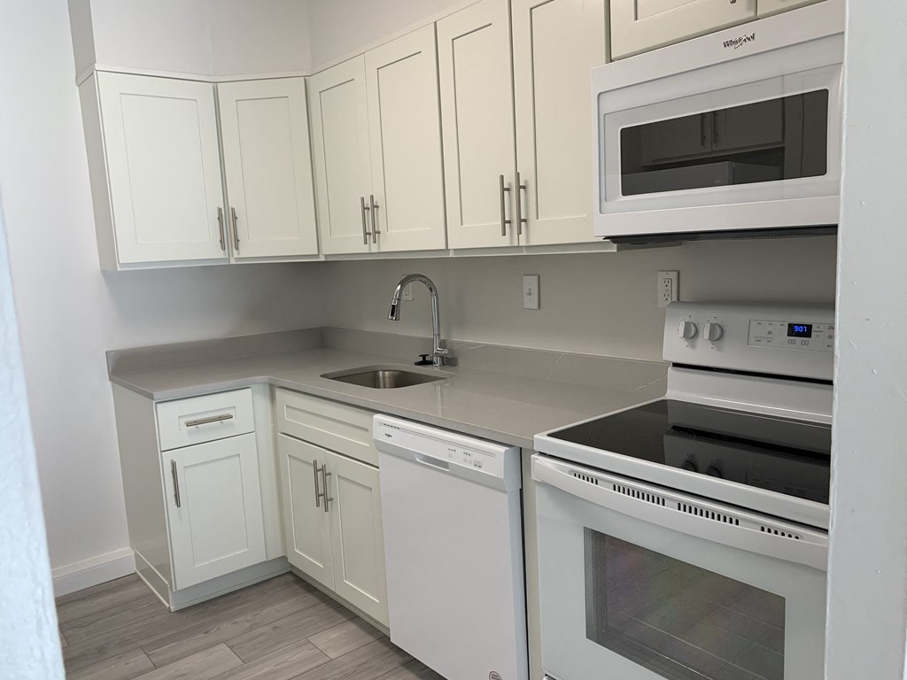 a kitchen with white cabinets and white appliances