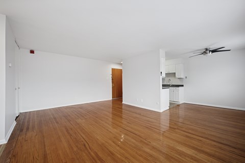 A room with wooden floors and a ceiling fan.