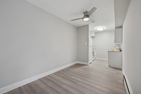 A room with a ceiling fan and light fixture, and a cabinet with a yellow object on top.