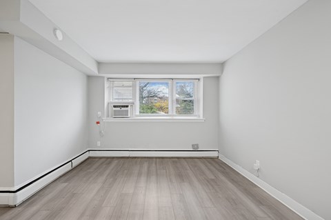 A room with a window and a microwave on the counter.