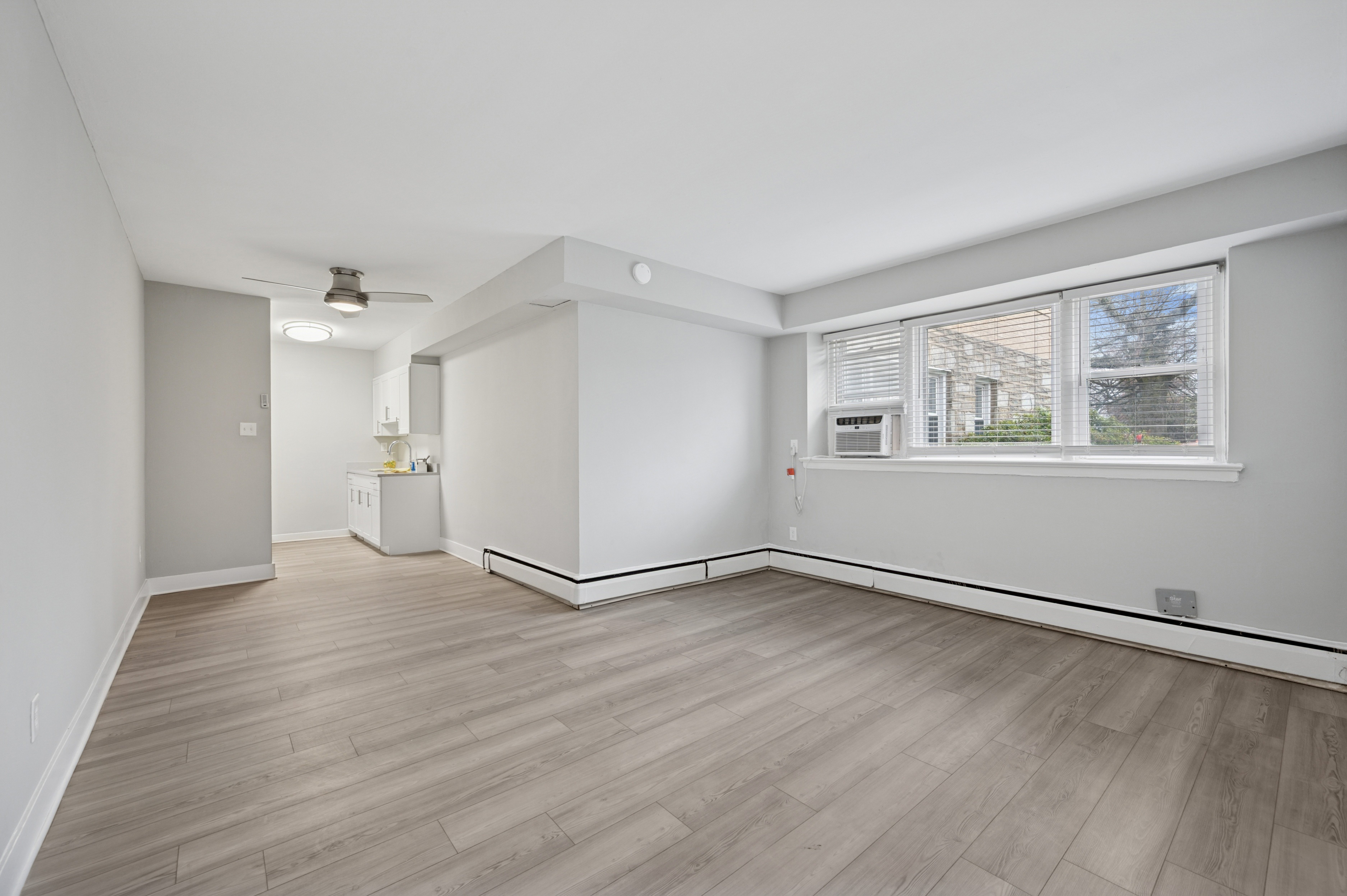 A room with a window and a white cabinet.