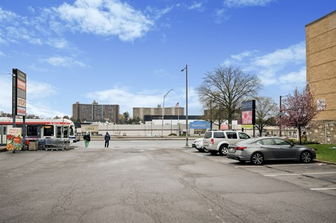 A parking lot with cars and a person standing in the middle.