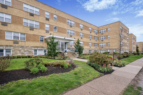 A large apartment complex with a landscaped garden in front.