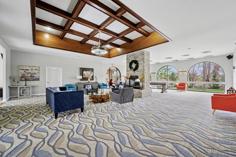 A living room with a blue patterned carpet and a wooden ceiling.