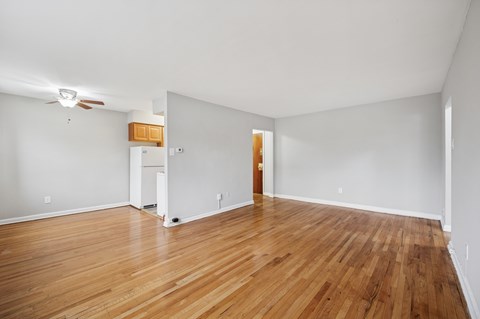 A room with wooden floors and a ceiling fan.