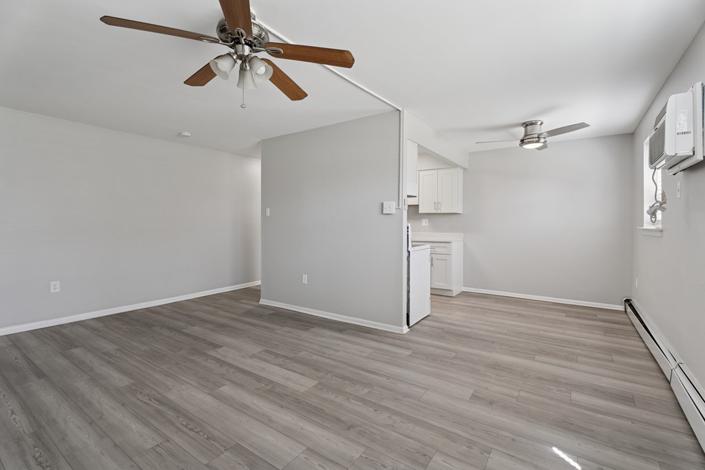 A room with a ceiling fan and a refrigerator.