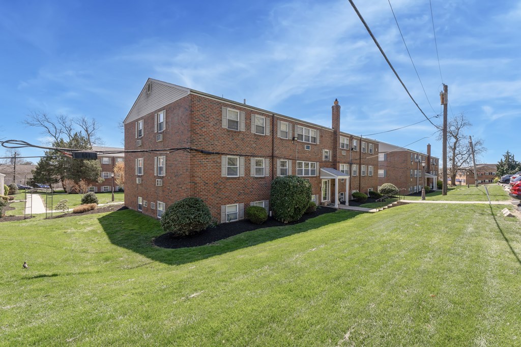 A large brick building with a green lawn in front.