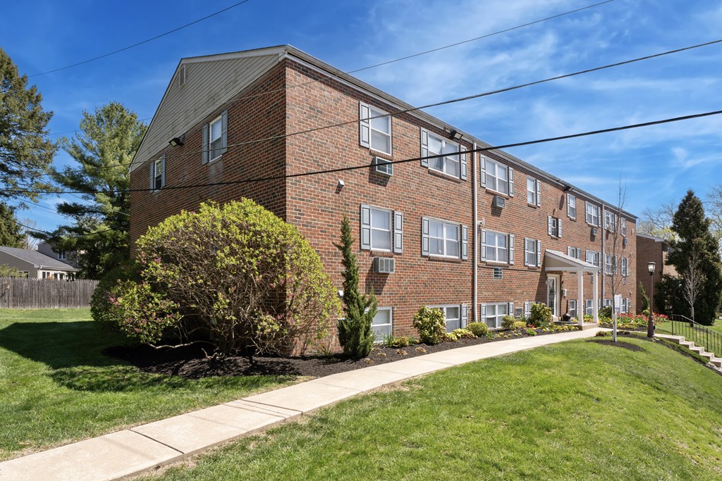 A brick apartment building with a green lawn in front.