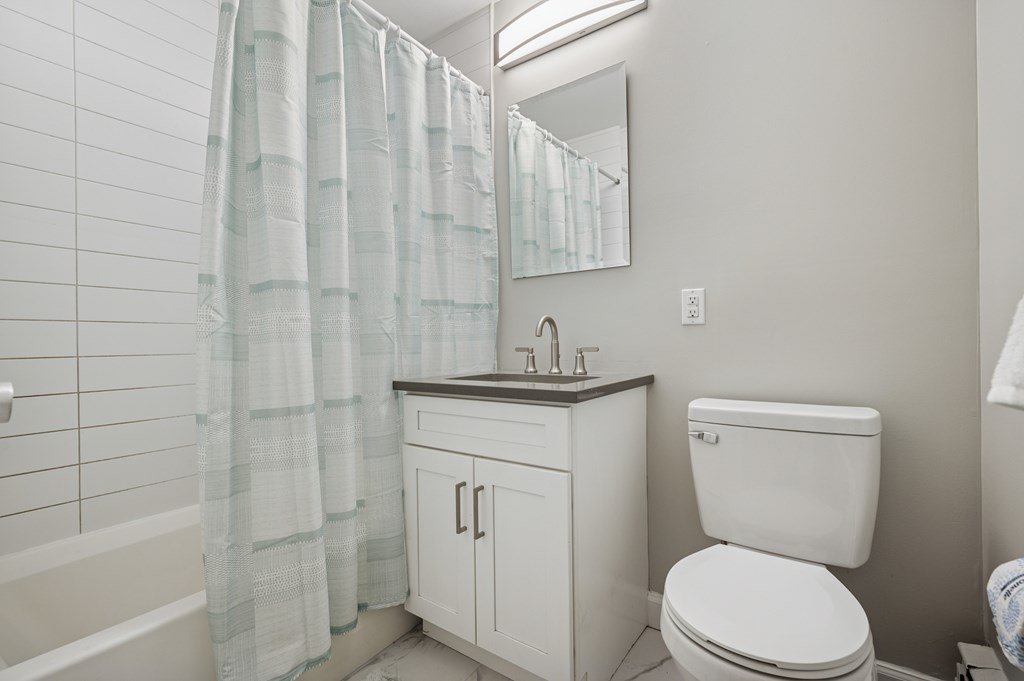 A white toilet sits next to a sink in a bathroom.