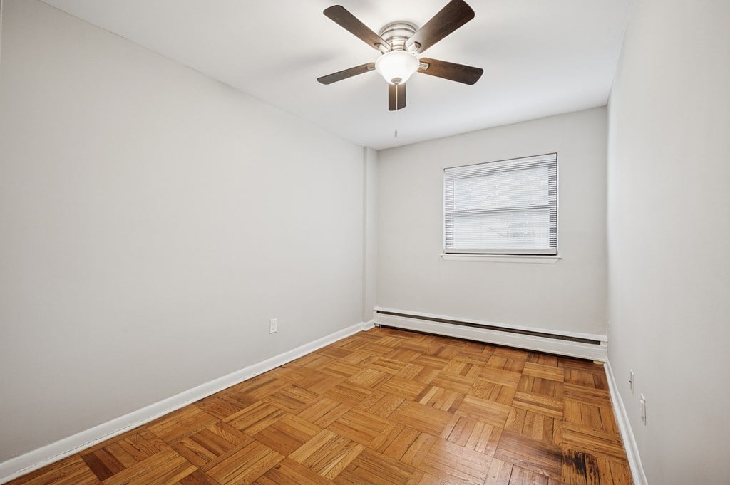 A room with a ceiling fan and a window.