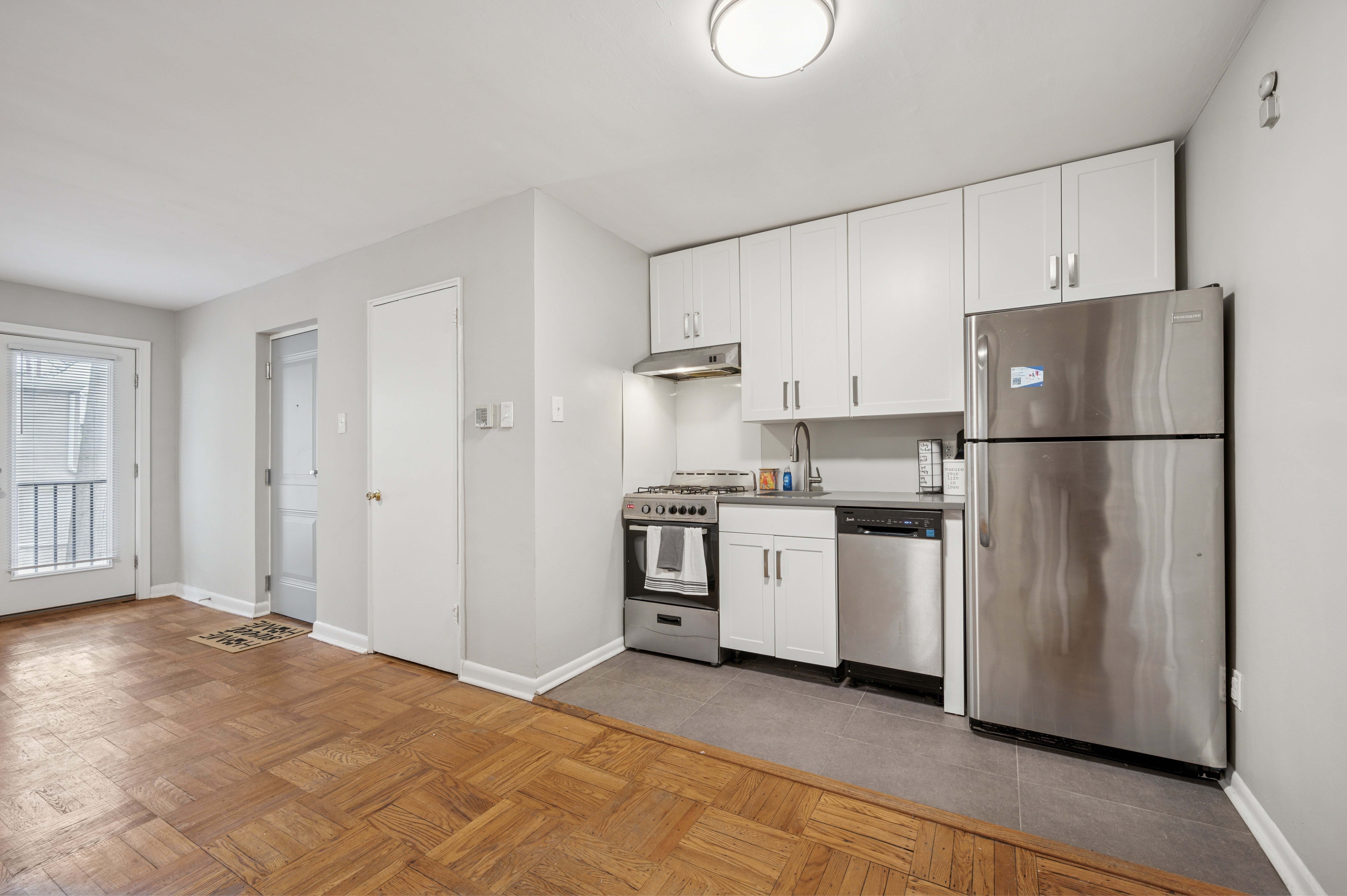 A kitchen with stainless steel appliances and wooden floors.