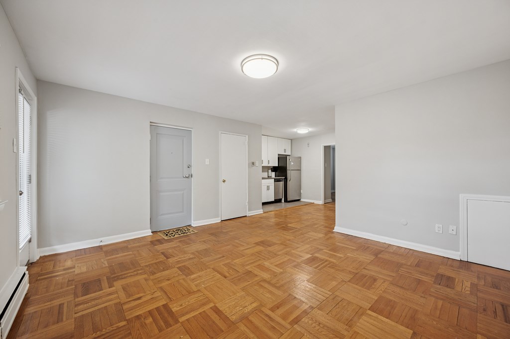 A room with wooden flooring and white walls.