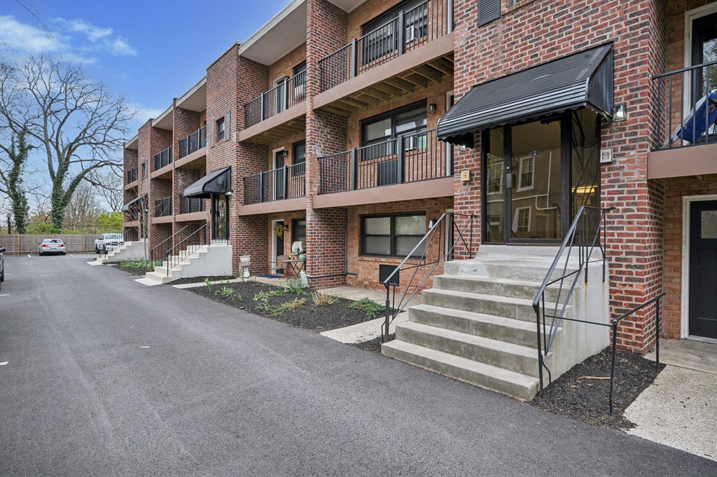 A brick apartment building with a black awning and a black metal railing.