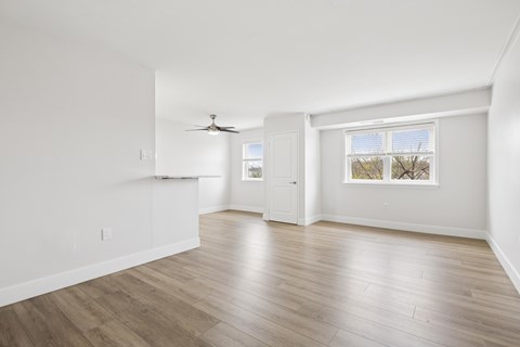 A room with a ceiling fan and a window with blinds.