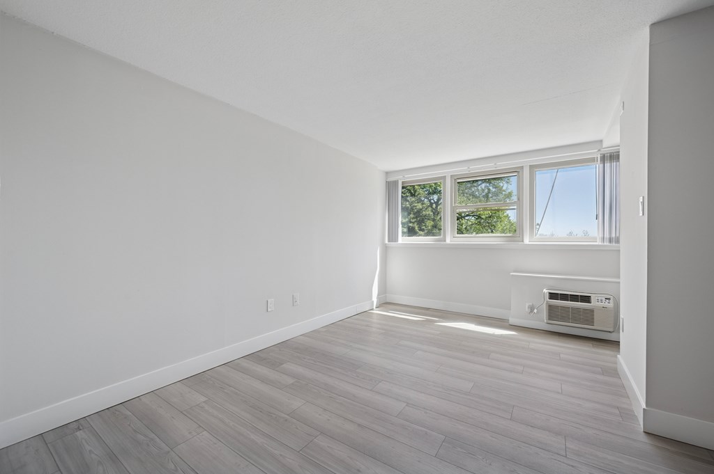 A room with a window and a wall-mounted air conditioner.