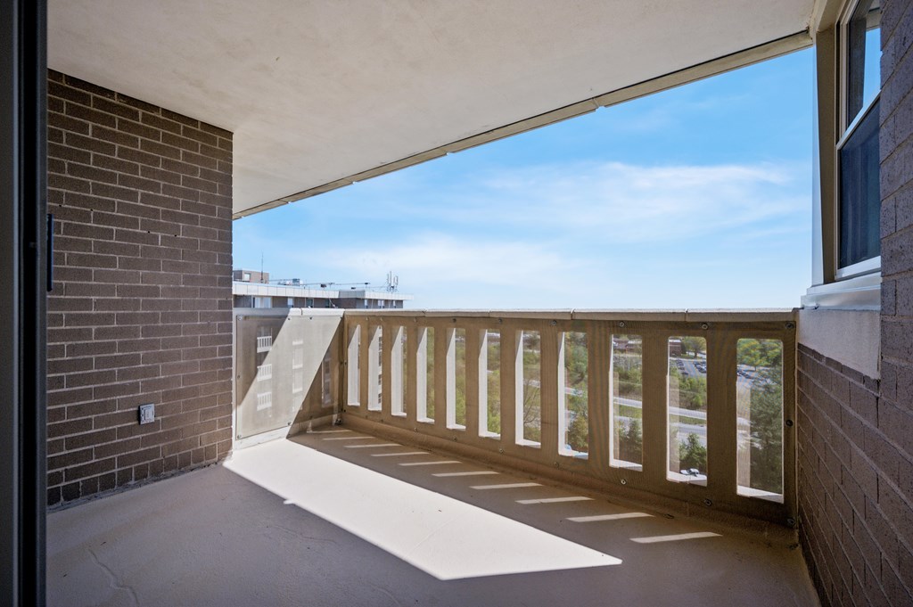 A balcony with a wooden railing and a white floor.