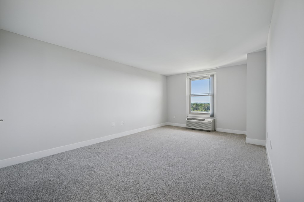 A room with a window and a radiator on the wall.