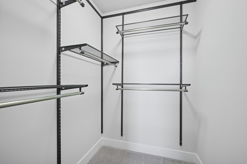A white wall with a shelf and a rack.
