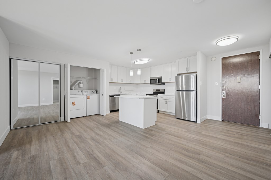 A modern kitchen with white cabinets and stainless steel appliances.