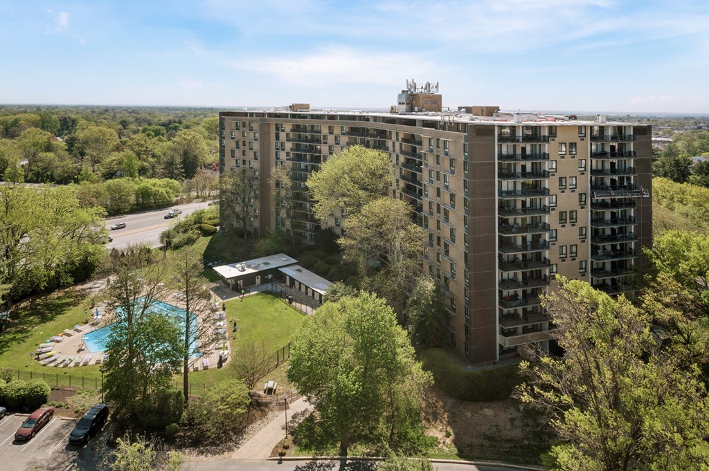 A large apartment complex with a pool and greenery.